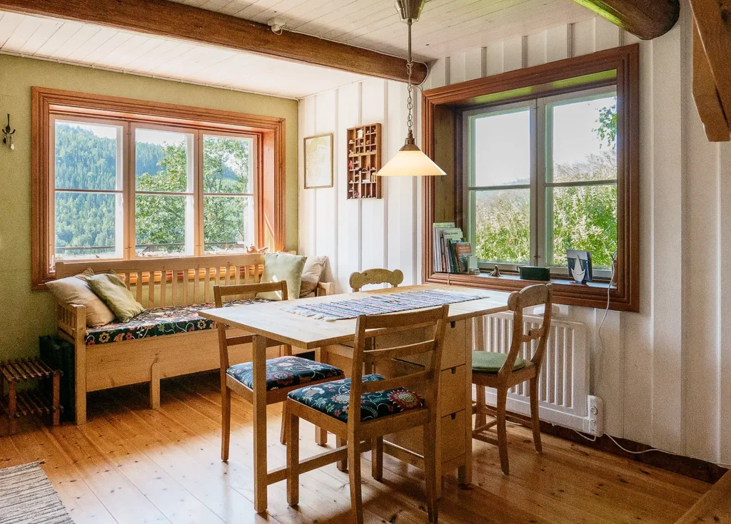 Vardagsrummet med matbord och soffa samt fönster i två väderstreck